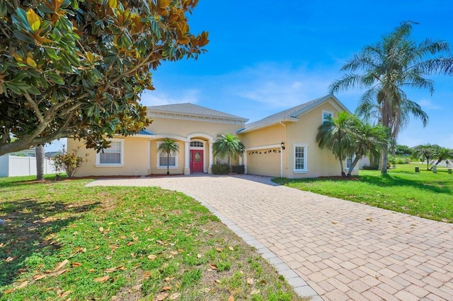 5556 Vintage View Blvd, Lakeland, FL 33812 - mediterranean / spanish house with an attached garage, decorative driveway, stucco siding, and a front yard