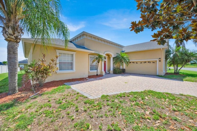 5556 Vintage View Blvd, Lakeland, FL 33812 - view of front facade with stucco siding, an attached garage, and decorative driveway