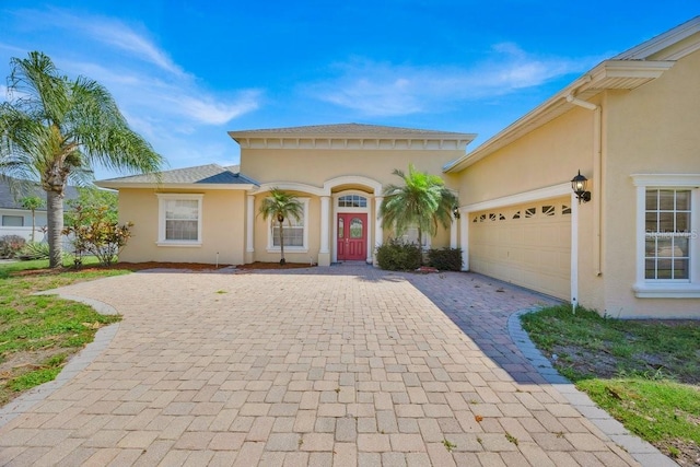 5556 Vintage View Blvd, Lakeland, FL 33812 - mediterranean / spanish home featuring stucco siding, decorative driveway, and an attached garage