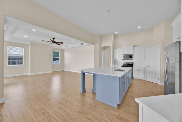 5556 Vintage View Blvd, Lakeland, FL 33812 - kitchen with appliances with stainless steel finishes, a sink, a ceiling fan, arched walkways, and white cabinetry