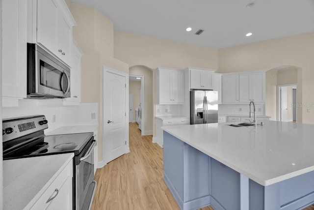 5556 Vintage View Blvd, Lakeland, FL 33812 - kitchen featuring stainless steel appliances, arched walkways, a sink, light countertops, and recessed lighting