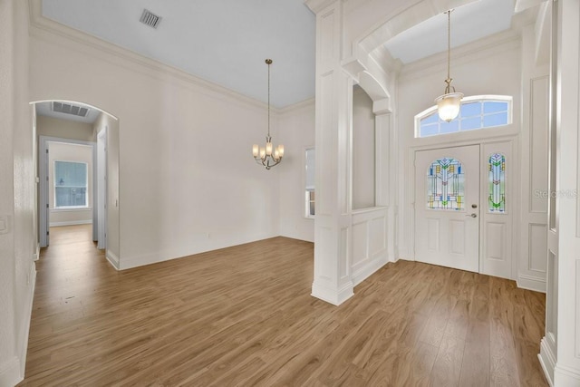 5556 Vintage View Blvd, Lakeland, FL 33812 - foyer with arched walkways, light wood-type flooring, crown molding, a chandelier, and a towering ceiling