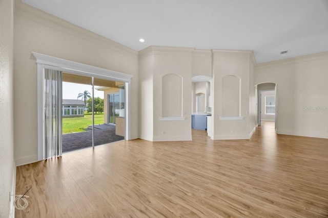 5556 Vintage View Blvd, Lakeland, FL 33812 - unfurnished room featuring ornamental molding, arched walkways, light wood-style floors, and baseboards