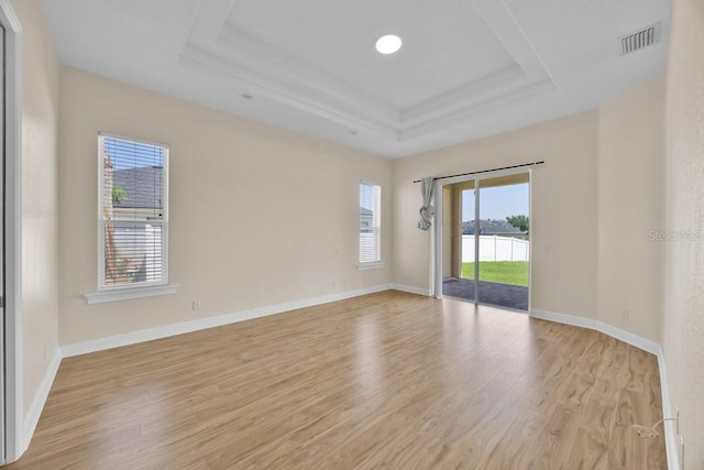 5556 Vintage View Blvd, Lakeland, FL 33812 - empty room featuring a tray ceiling, light wood-style flooring, baseboards, ornamental molding, and a water view