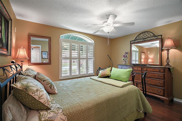 215 Chula Vista Ave, The Villages, FL 32159 - bedroom featuring dark wood finished floors, a textured ceiling, a ceiling fan, and baseboards