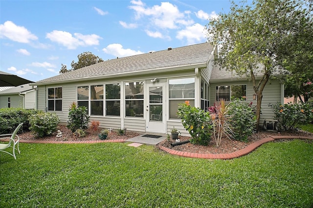 215 Chula Vista Ave, The Villages, FL 32159 - rear view of property featuring roof with shingles, a yard, and a sunroom
