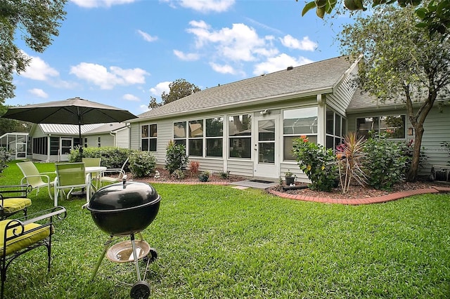 215 Chula Vista Ave, The Villages, FL 32159 - rear view of house featuring roof with shingles, a yard, and a sunroom