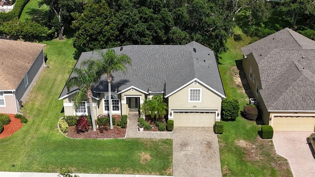 4239 Fawn Meadows Cir, Clermont, FL 34711 - view of front of house featuring driveway, stucco siding, a front yard, and roof with shingles