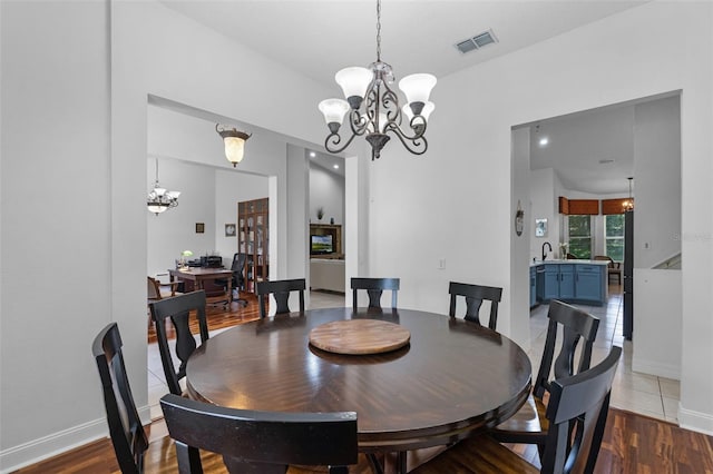 4239 Fawn Meadows Cir, Clermont, FL 34711 - dining room with a chandelier, wood finished floors, and baseboards