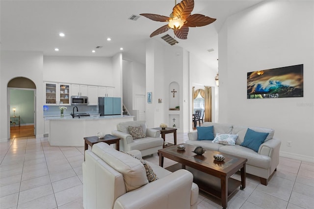4239 Fawn Meadows Cir, Clermont, FL 34711 - living area featuring high vaulted ceiling, arched walkways, light tile patterned floors, a ceiling fan, and baseboards