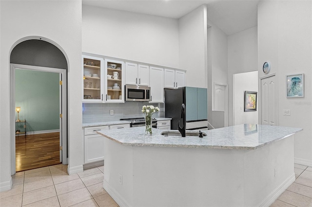 4239 Fawn Meadows Cir, Clermont, FL 34711 - kitchen with appliances with stainless steel finishes, high vaulted ceiling, light tile patterned floors, white cabinets, and baseboards