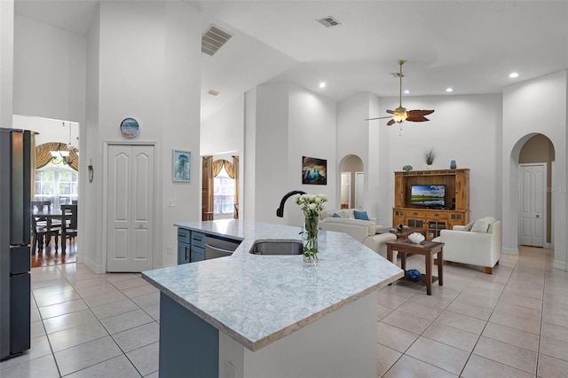 4239 Fawn Meadows Cir, Clermont, FL 34711 - kitchen featuring a sink, arched walkways, freestanding refrigerator, ceiling fan, and light tile patterned floors