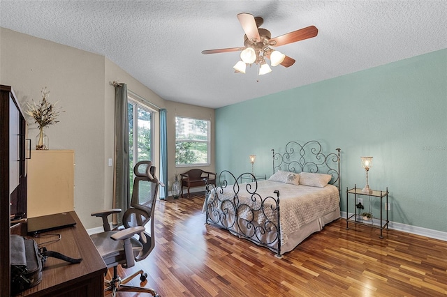 4239 Fawn Meadows Cir, Clermont, FL 34711 - bedroom featuring wood finished floors, a textured ceiling, a desk, baseboards, and ceiling fan