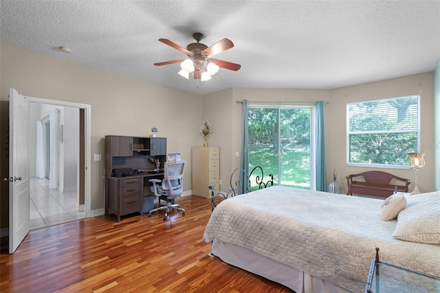 4239 Fawn Meadows Cir, Clermont, FL 34711 - bedroom featuring light wood-style floors, a textured ceiling, an office area, ceiling fan, and baseboards