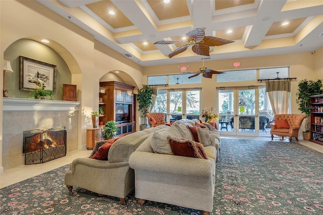 4239 Fawn Meadows Cir, Clermont, FL 34711 - living room with a towering ceiling, a ceiling fan, coffered ceiling, french doors, and a tile fireplace