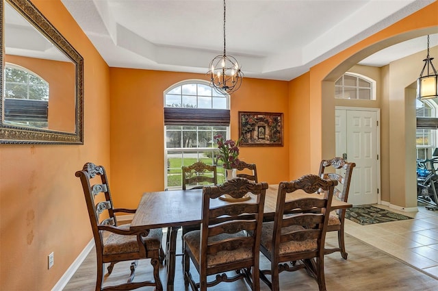 34231 Shadewood Cir, Leesburg, FL 34788 - dining room featuring arched walkways, healthy amount of natural light, a chandelier, and a tray ceiling