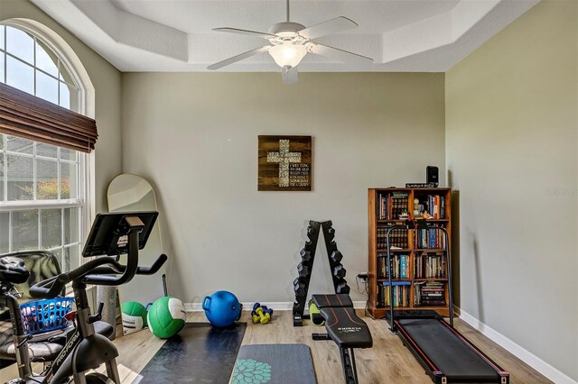 34231 Shadewood Cir, Leesburg, FL 34788 - workout area with wood finished floors, baseboards, ceiling fan, and a raised ceiling