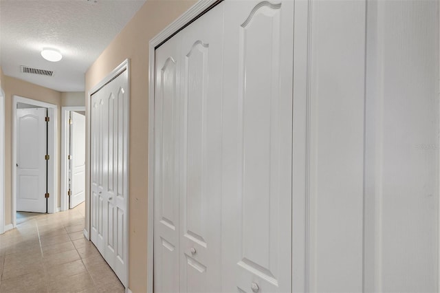 34231 Shadewood Cir, Leesburg, FL 34788 - hallway with a textured ceiling, light tile patterned floors, and baseboards