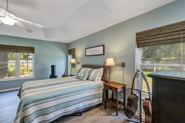 34231 Shadewood Cir, Leesburg, FL 34788 - bedroom featuring wood finished floors, baseboards, a tray ceiling, and ceiling fan