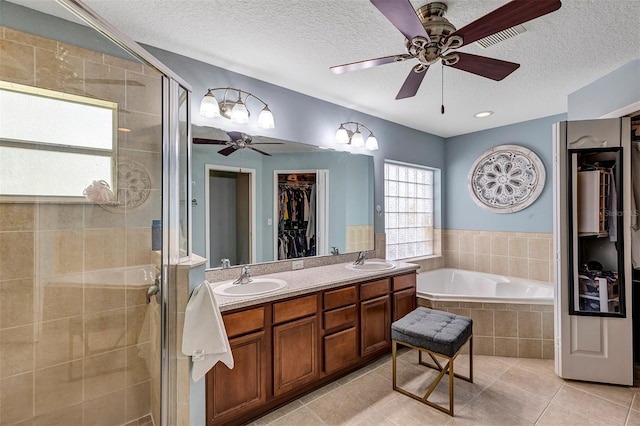 34231 Shadewood Cir, Leesburg, FL 34788 - full bathroom featuring a ceiling fan, a walk in closet, a textured ceiling, a bath, and a shower stall