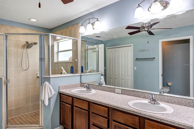 34231 Shadewood Cir, Leesburg, FL 34788 - full bathroom with a ceiling fan, double vanity, a stall shower, toilet, and a textured ceiling