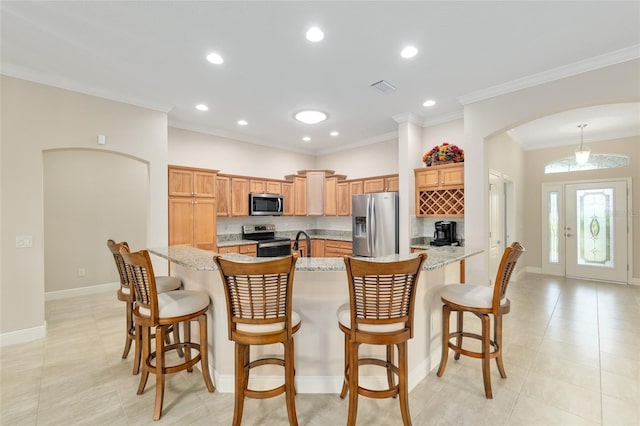 3097 Bureau Path, The Villages, FL 32163 - kitchen featuring appliances with stainless steel finishes, arched walkways, baseboards, a kitchen bar, and crown molding