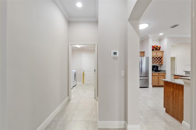 3097 Bureau Path, The Villages, FL 32163 - corridor featuring ornamental molding, light tile patterned flooring, washer / dryer, baseboards, and arched walkways