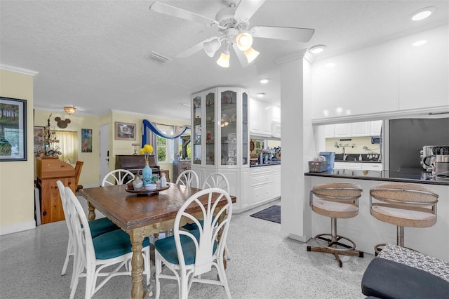 101 Lakeshore Blvd, Saint Cloud, FL 34769 - dining area featuring dark speckled floor, ceiling fan, a textured ceiling, crown molding, and baseboards