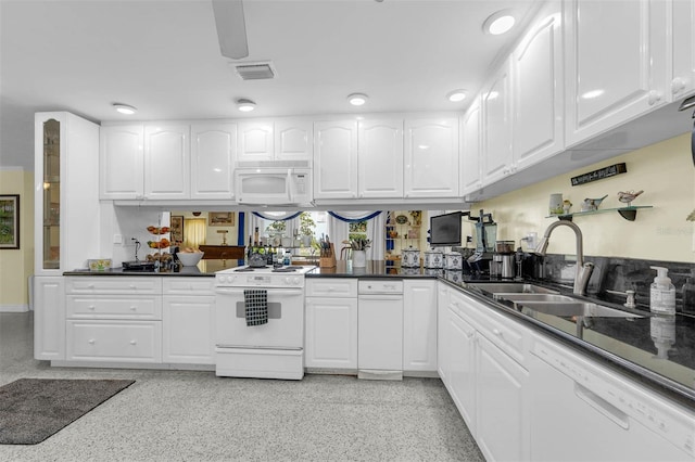 101 Lakeshore Blvd, Saint Cloud, FL 34769 - kitchen with white appliances, a sink, white cabinetry, and dark countertops