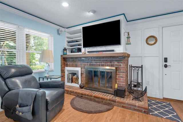 101 Lakeshore Blvd, Saint Cloud, FL 34769 - living area with crown molding, a textured ceiling, wood finished floors, and a brick fireplace