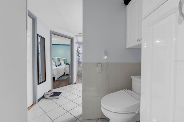 101 Lakeshore Blvd, Saint Cloud, FL 34769 - ensuite bathroom featuring tile walls, toilet, tile patterned flooring, and wainscoting