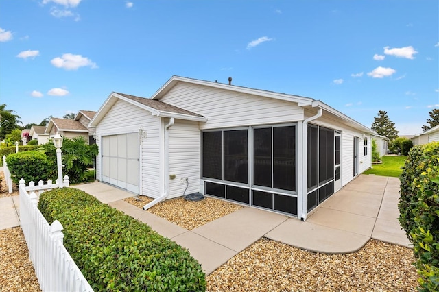 2317 Whisper St, The Villages, FL 32162 - rear view of property featuring a sunroom and a garage