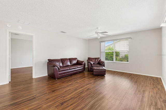 2317 Whisper St, The Villages, FL 32162 - living room featuring dark wood finished floors, a textured ceiling, ceiling fan, and baseboards