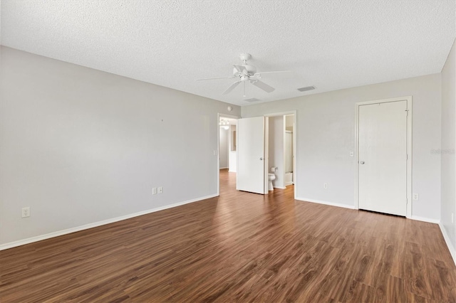 2317 Whisper St, The Villages, FL 32162 - unfurnished bedroom featuring dark wood-style flooring, baseboards, a textured ceiling, a ceiling fan, and ensuite bath