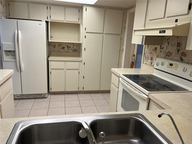 11812 Watts Ct, Tavares, FL 32778 - kitchen featuring white appliances, cream cabinets, light countertops, and light tile patterned floors