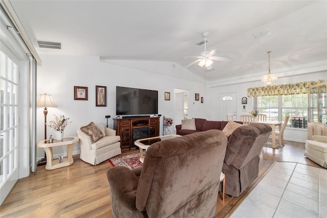 8850 SE 156th St, Summerfield, FL 34491 - living area featuring vaulted ceiling, light wood-style flooring, a ceiling fan, and a chandelier