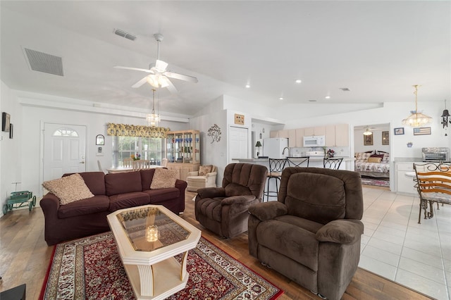 8850 SE 156th St, Summerfield, FL 34491 - living room featuring lofted ceiling, a chandelier, a ceiling fan, and light wood-type flooring