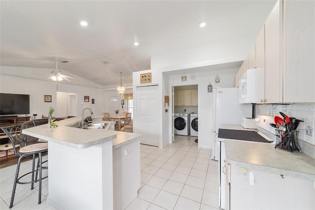 8850 SE 156th St, Summerfield, FL 34491 - kitchen featuring separate washer and dryer, white appliances, light countertops, lofted ceiling, and light tile patterned flooring