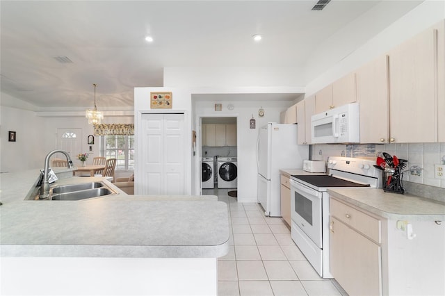 8850 SE 156th St, Summerfield, FL 34491 - kitchen with white appliances, washer and dryer, light countertops, light tile patterned flooring, and a chandelier