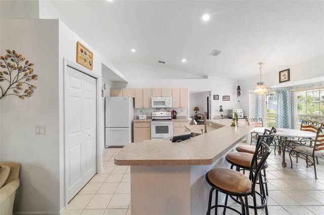 8850 SE 156th St, Summerfield, FL 34491 - kitchen featuring white appliances, light tile patterned floors, light countertops, light brown cabinetry, and a breakfast bar area