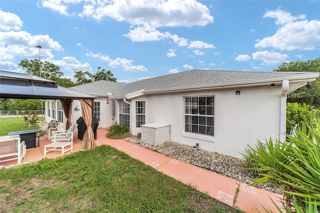 8850 SE 156th St, Summerfield, FL 34491 - view of front of house featuring a gazebo, stucco siding, a patio area, and roof with shingles