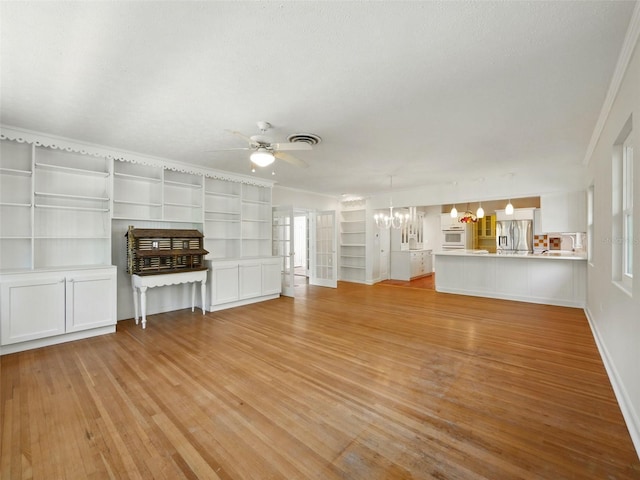 9269 Silver Lake Dr, Leesburg, FL 34788 - unfurnished living room featuring ceiling fan, light wood-type flooring, a chandelier, baseboards, and crown molding