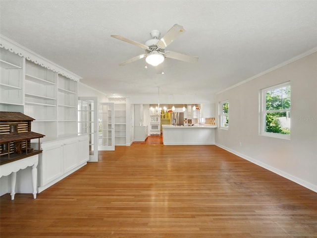 9269 Silver Lake Dr, Leesburg, FL 34788 - unfurnished living room featuring crown molding, light wood finished floors, a ceiling fan, a chandelier, and baseboards