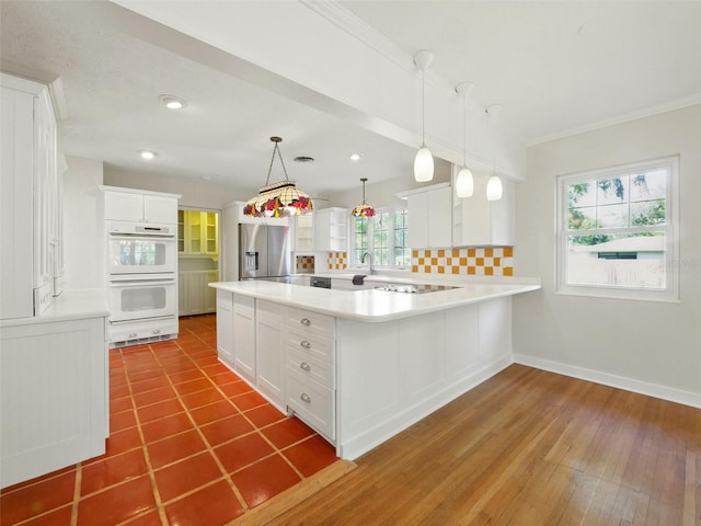 9269 Silver Lake Dr, Leesburg, FL 34788 - kitchen featuring white double oven, stainless steel fridge with ice dispenser, light countertops, white cabinets, and healthy amount of natural light