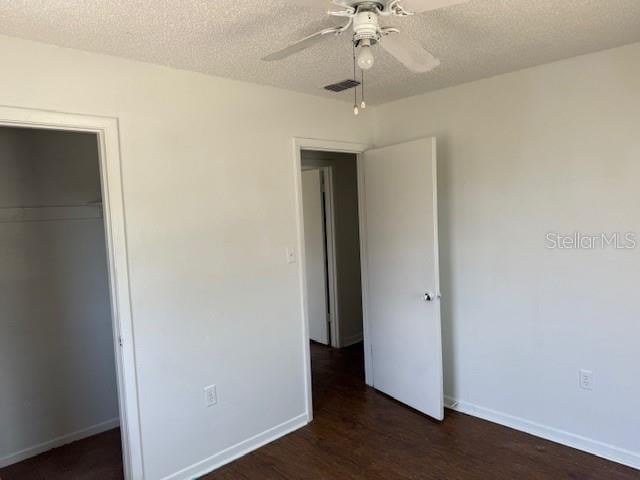 1109 Willow Ct, Tavares, FL 32778 - unfurnished bedroom with dark wood-style flooring, baseboards, a textured ceiling, a closet, and a ceiling fan
