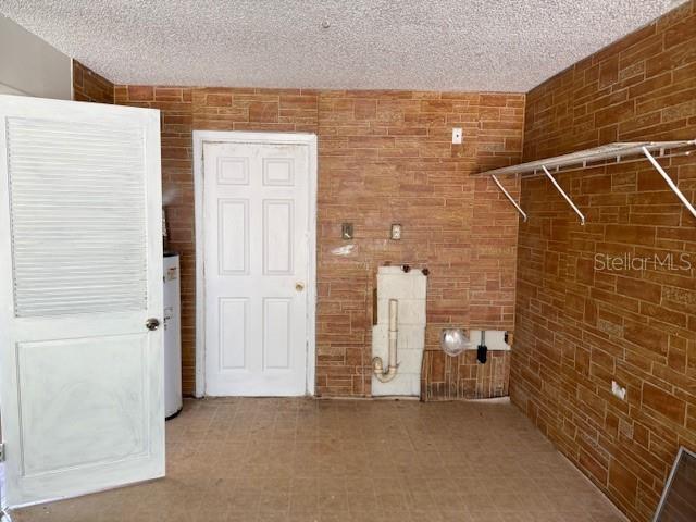 1109 Willow Ct, Tavares, FL 32778 - washroom featuring water heater and a textured ceiling