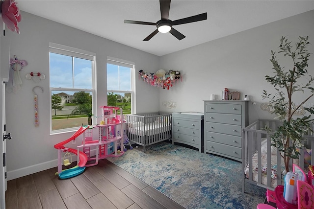 14501 Wabasso Loop, Winter Garden, FL 34787 - bedroom with baseboards, wood finished floors, a nursery area, and ceiling fan