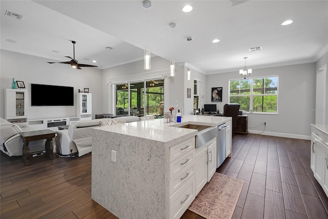 14501 Wabasso Loop, Winter Garden, FL 34787 - kitchen with dark wood-style floors, ornamental molding, open floor plan, white cabinets, and light stone countertops