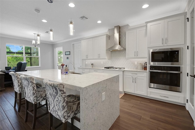 14501 Wabasso Loop, Winter Garden, FL 34787 - kitchen with appliances with stainless steel finishes, wall chimney exhaust hood, a sink, ornamental molding, and backsplash