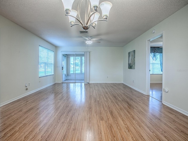 2799 Privada Dr, The Villages, FL 32162 - unfurnished room featuring light wood-style floors, a ceiling fan, a chandelier, and a textured ceiling